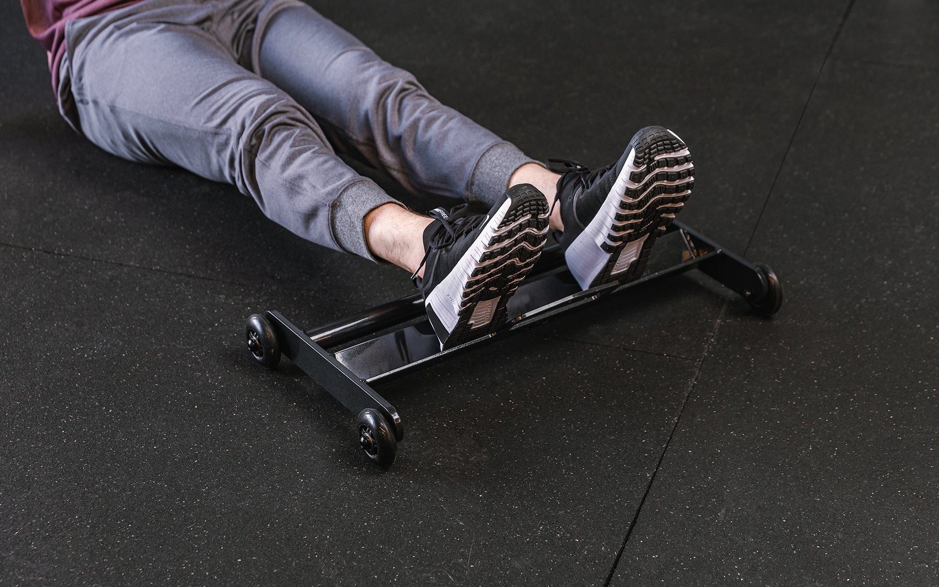 feet resting on the foot tray of the glute ham roller